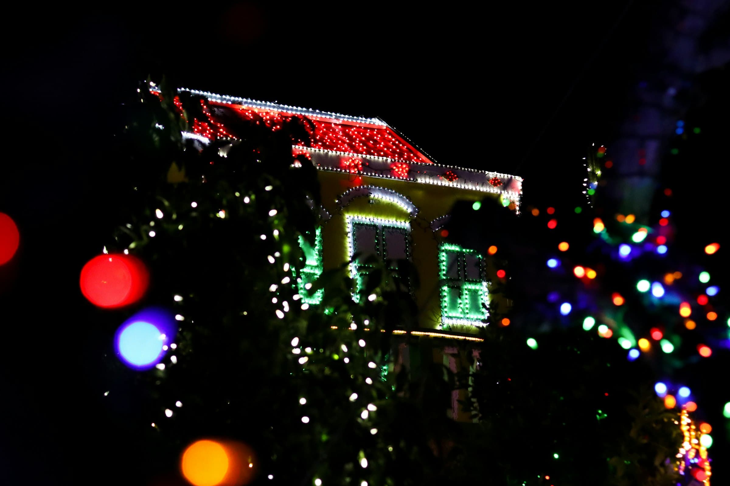 Finished holiday lighting on a home exterior at night